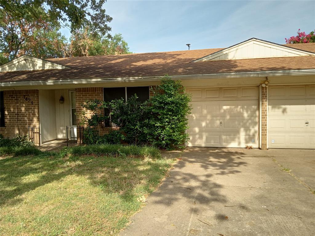 a view of a house with a garden and a tree