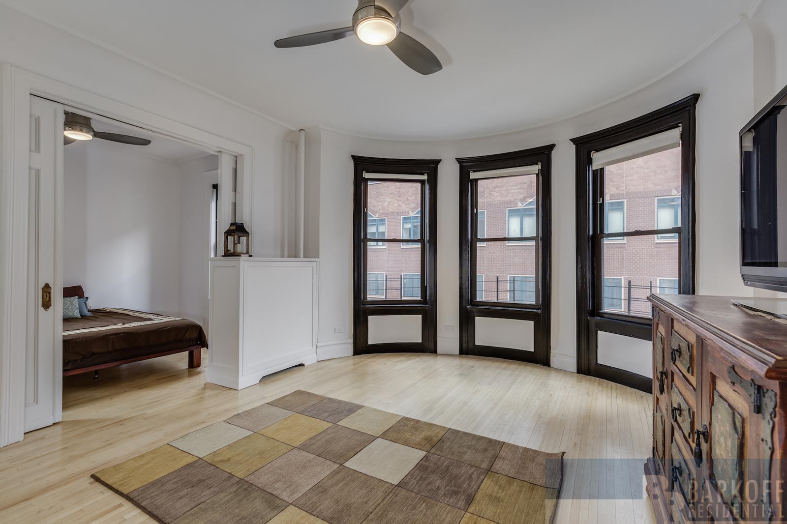 a view of an empty room with a window and a bedroom