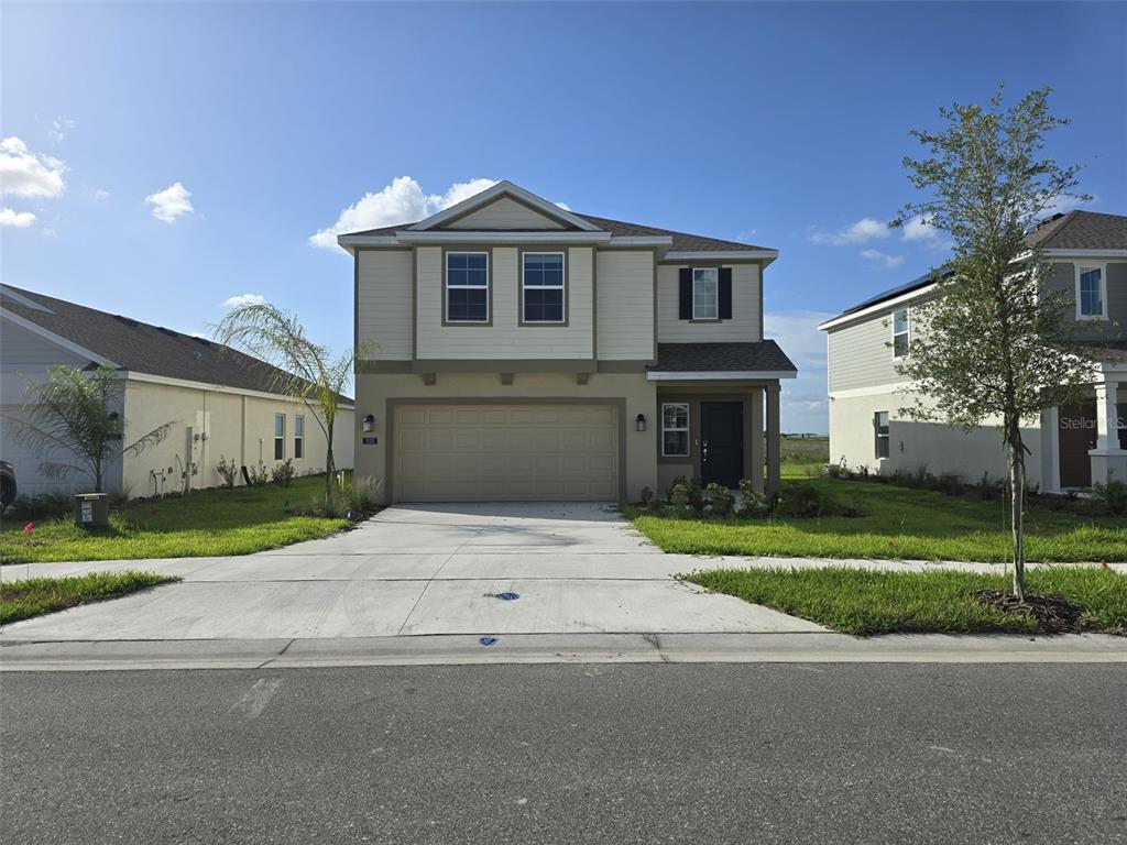 a front view of a house with a yard and garage