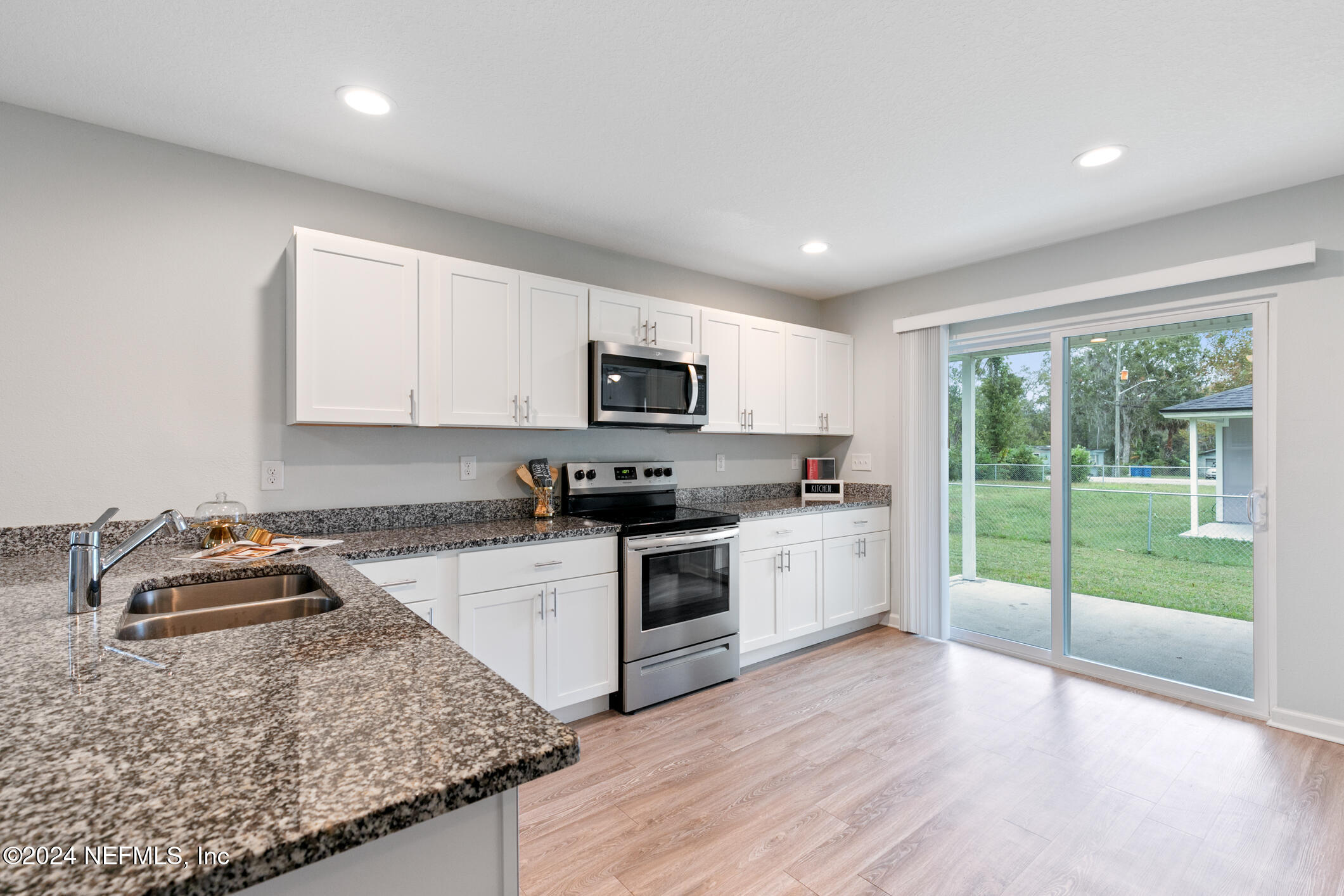 a kitchen with sink a stove and cabinets