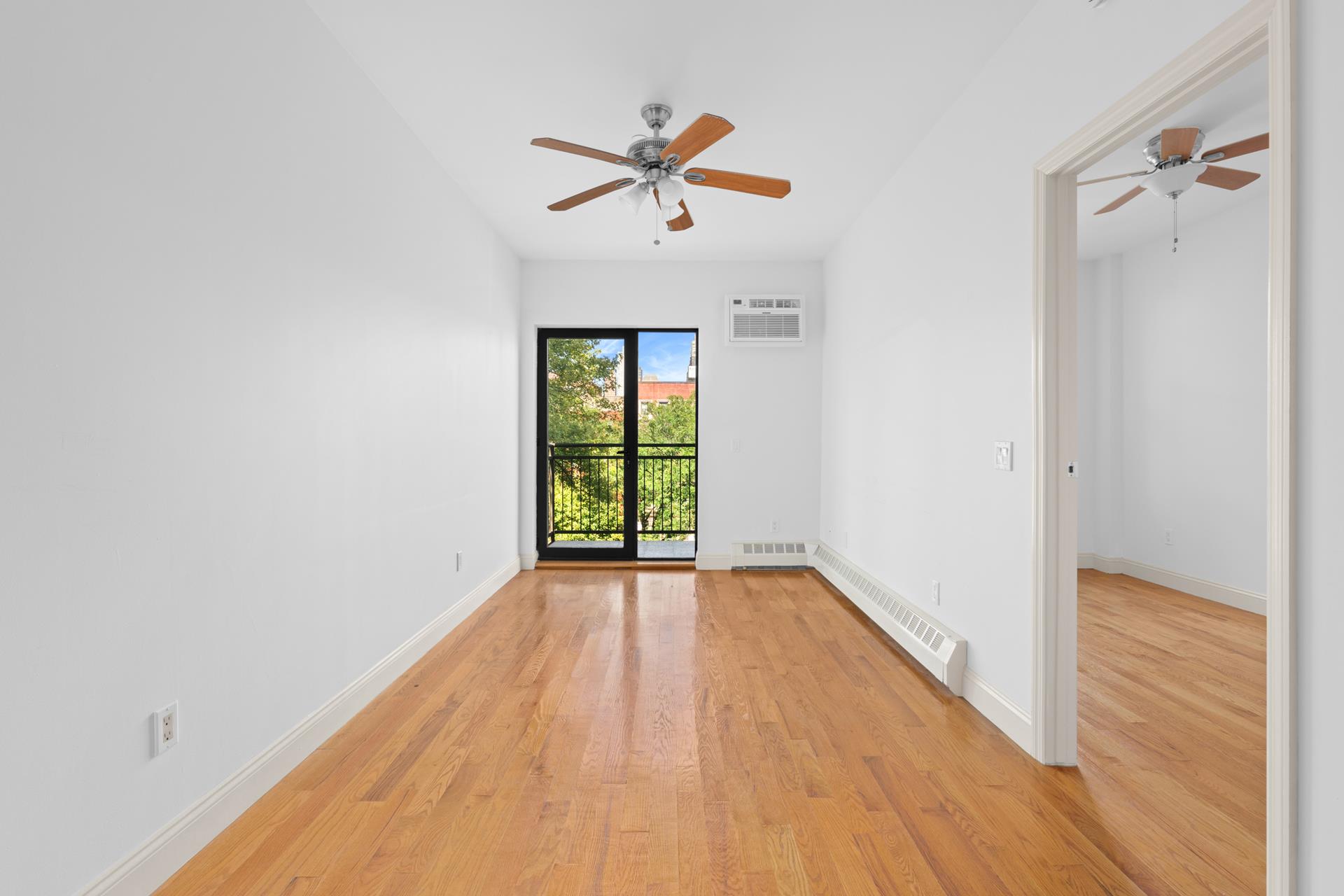 a view of a big room with wooden floor closet and windows