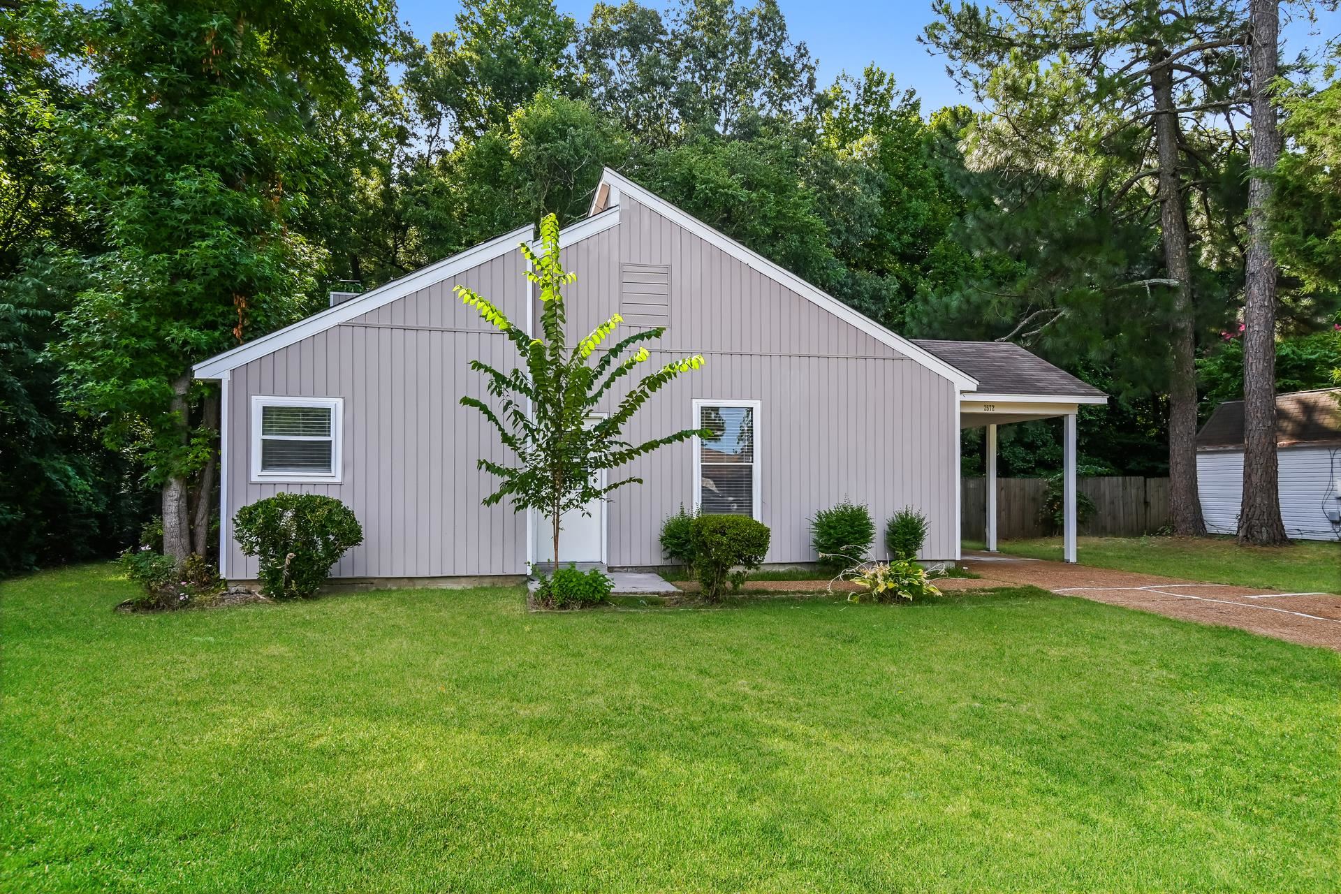 a front view of house with yard and green space