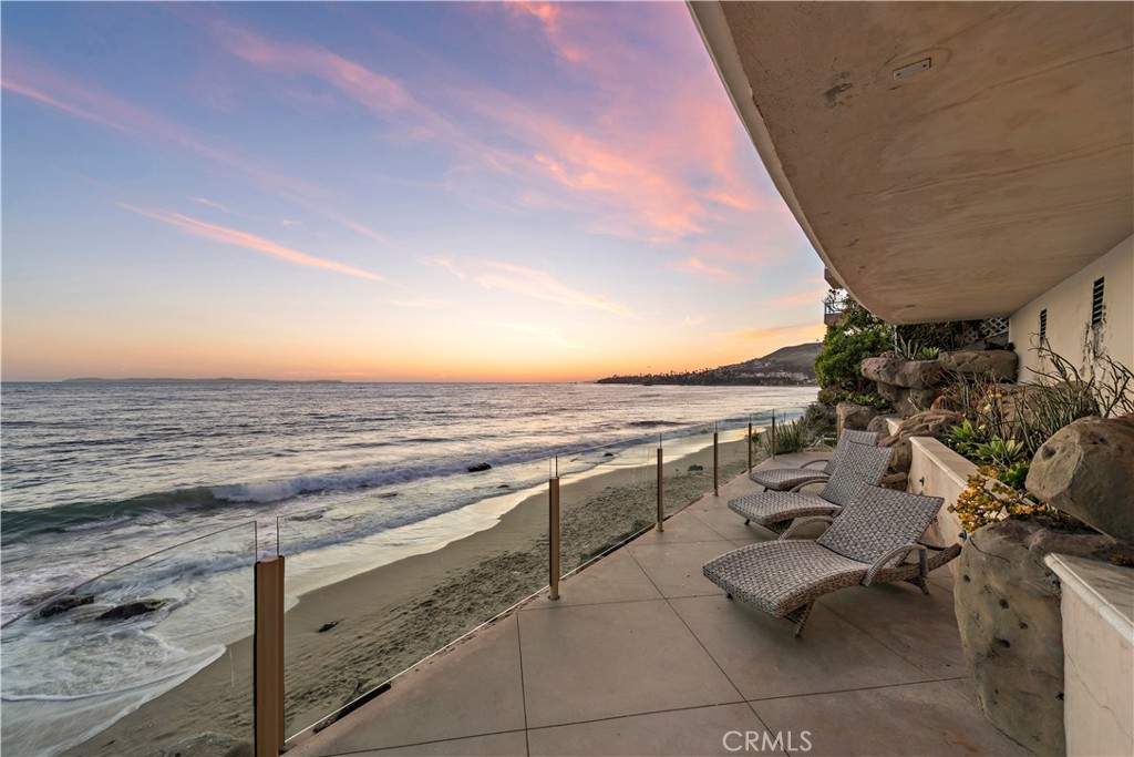 a view of a terrace with lawn chairs