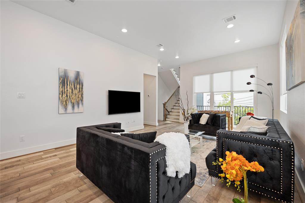 a living room with furniture a flat screen tv and a floor to ceiling window