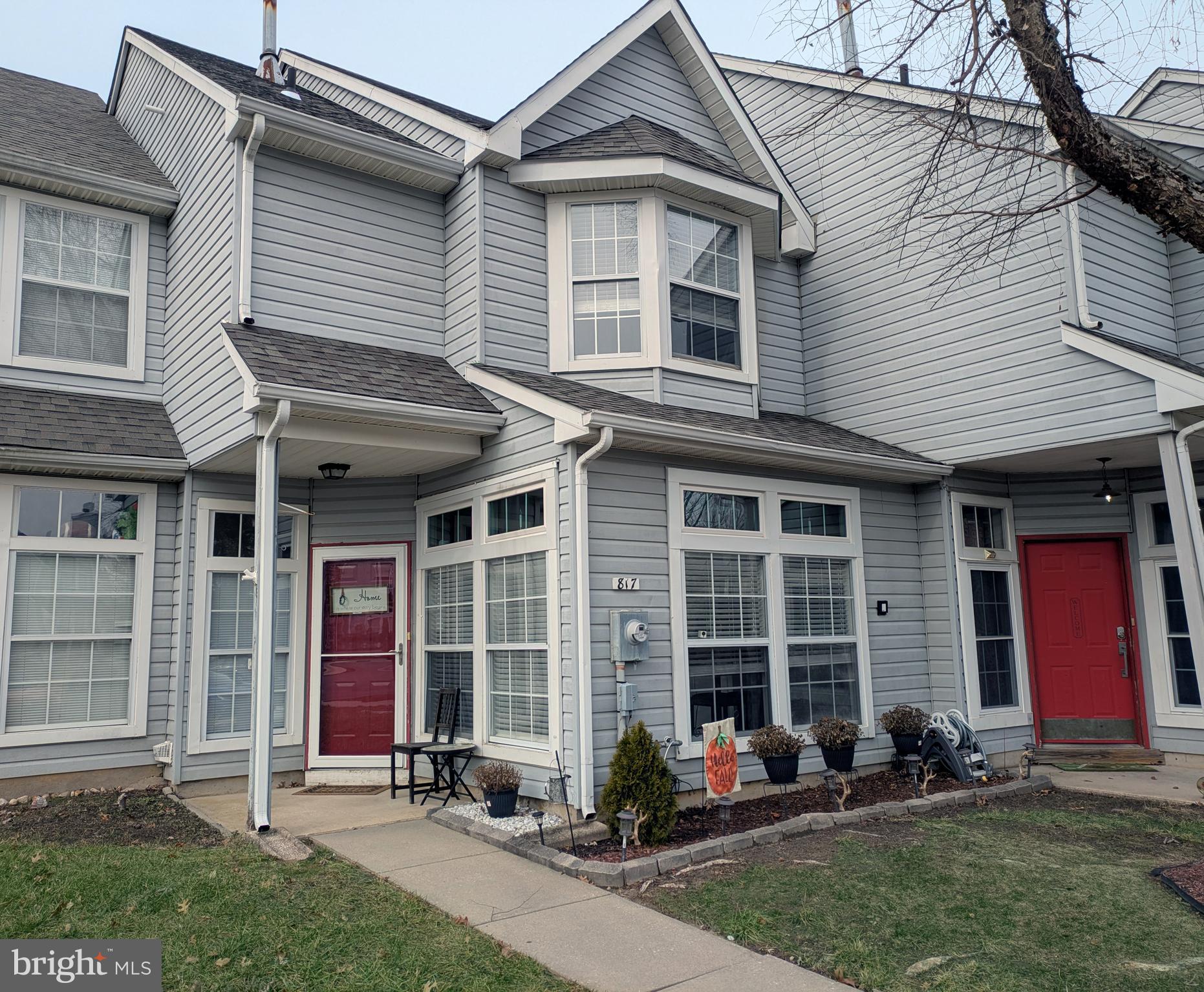 a front view of a house with a yard and seating space