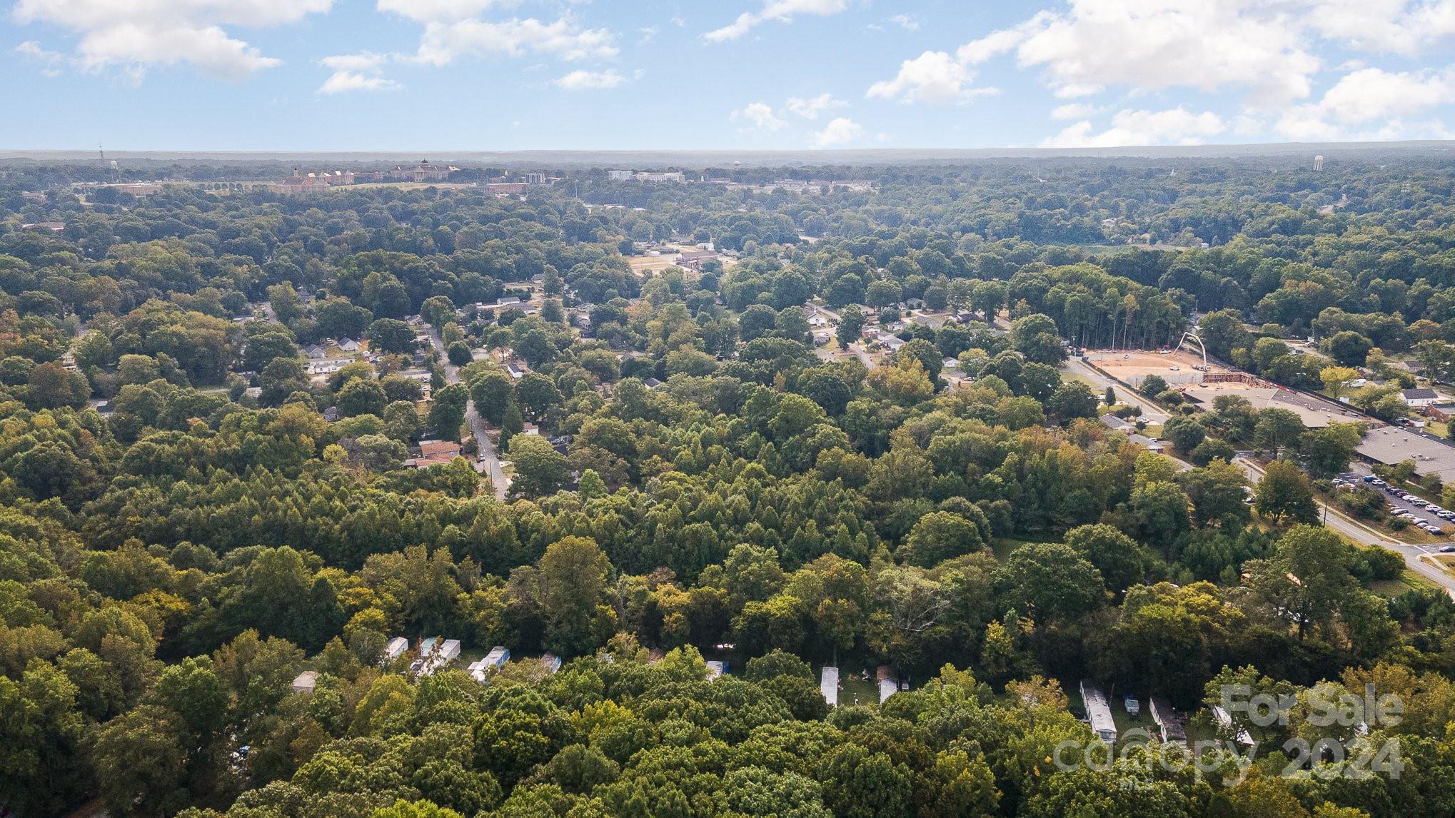 an aerial view of residential house with green space and mountain view in back