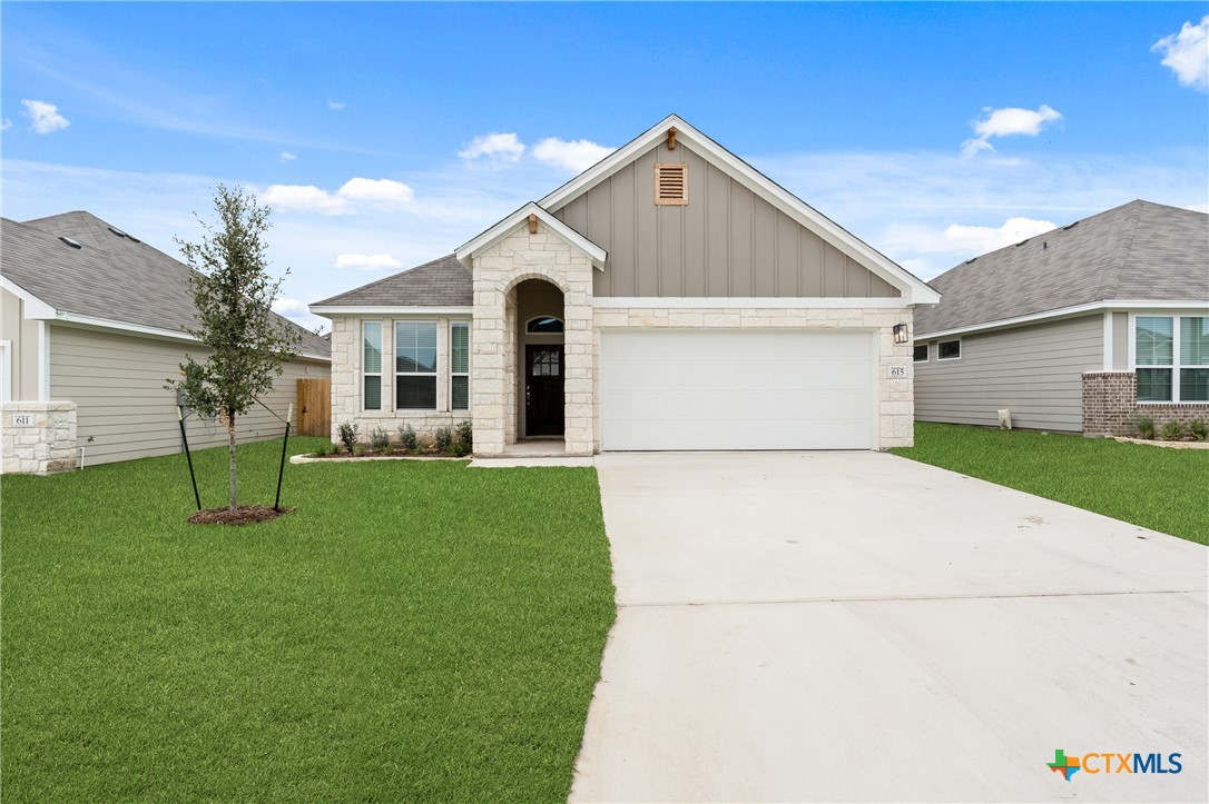 a front view of a house with a yard and garage