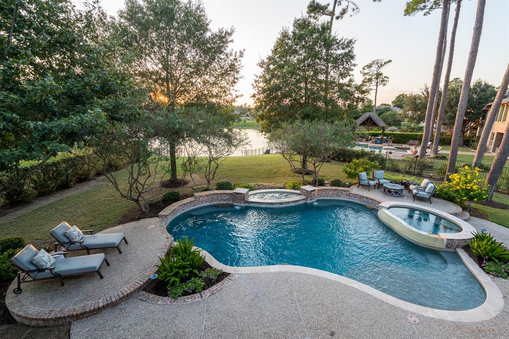 a view of a swimming pool with a chairs and plants