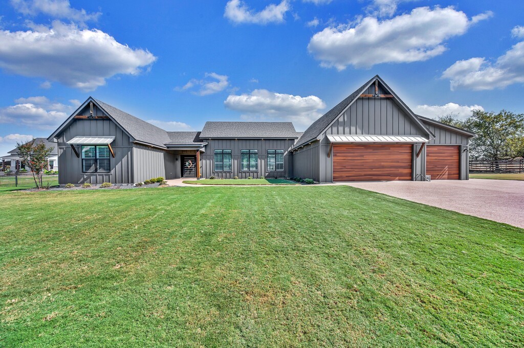 a front view of a house with yard and green space