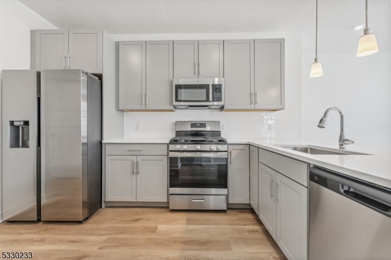 a kitchen with sink a microwave and refrigerator