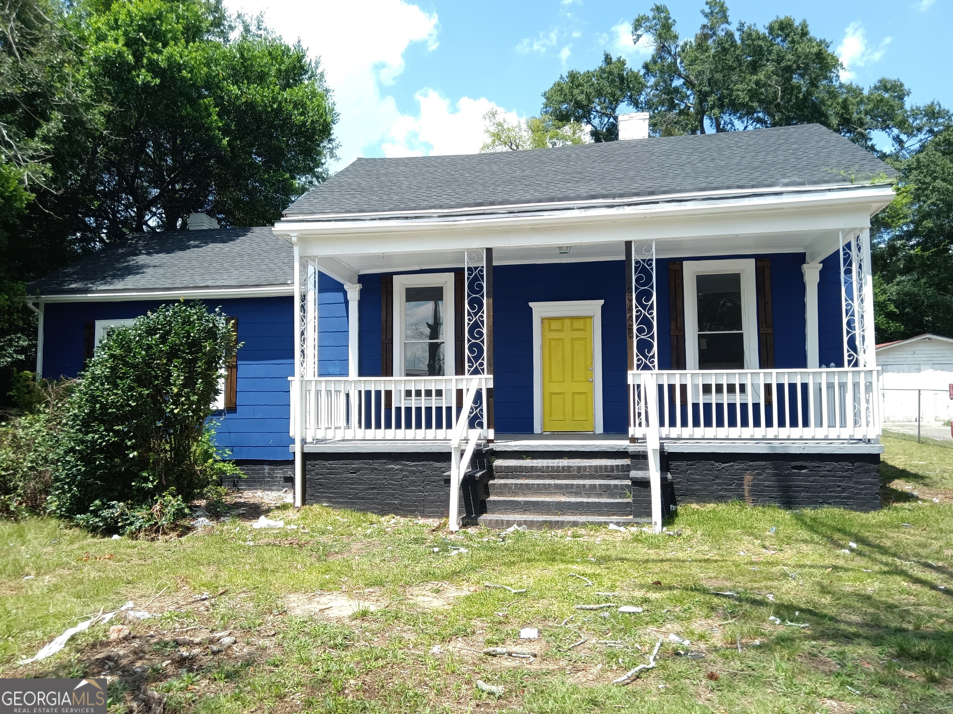 a view of a house with a small yard and wooden fence