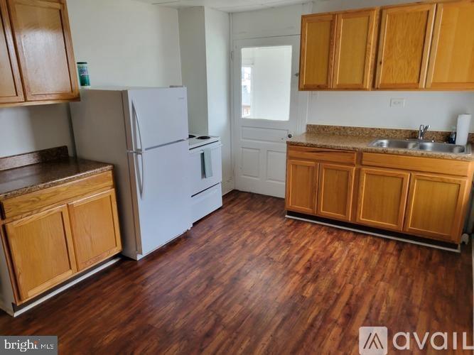 a kitchen with wooden floors and white appliances