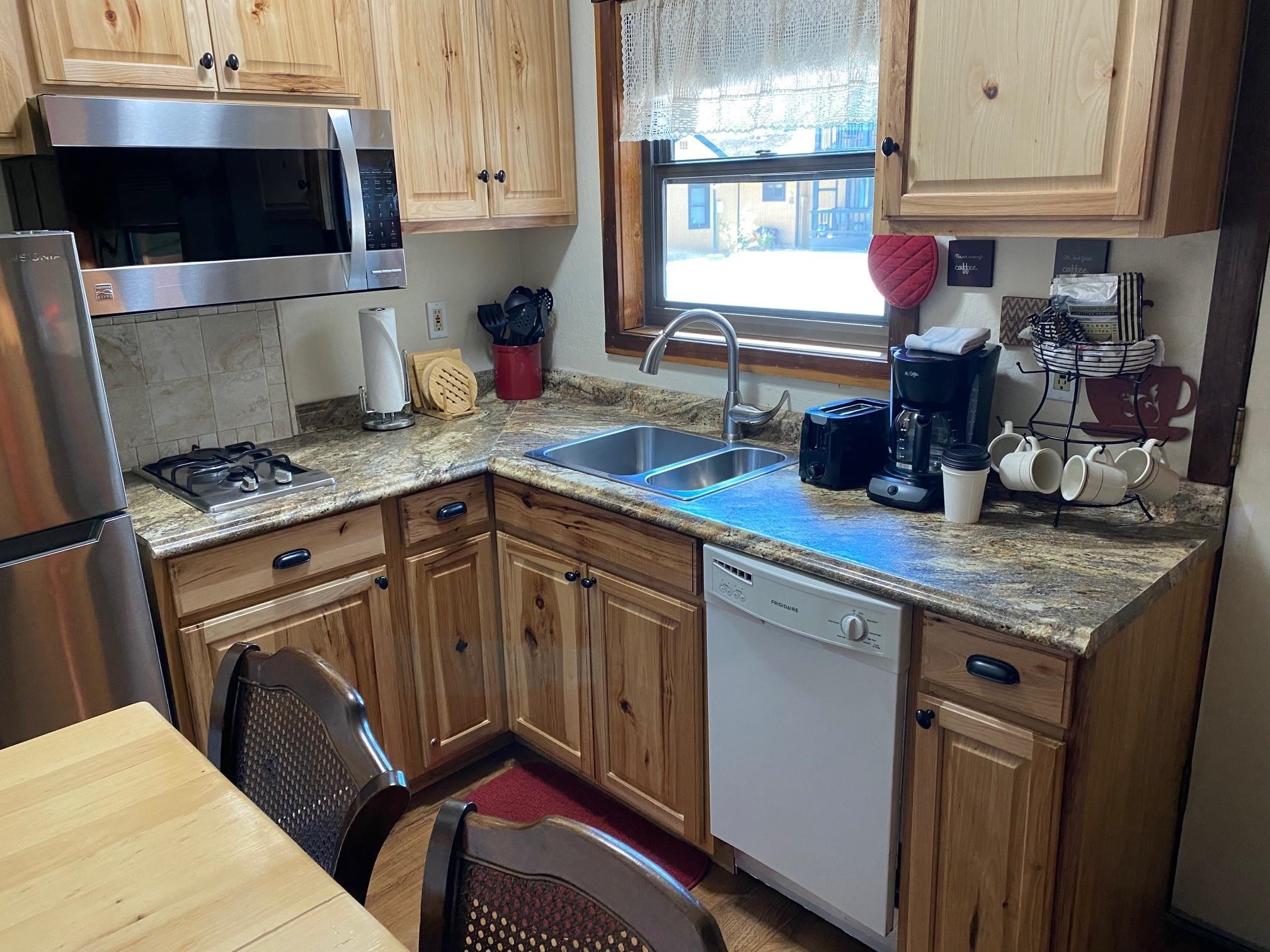 a kitchen with stainless steel appliances granite countertop a sink stove and cabinets