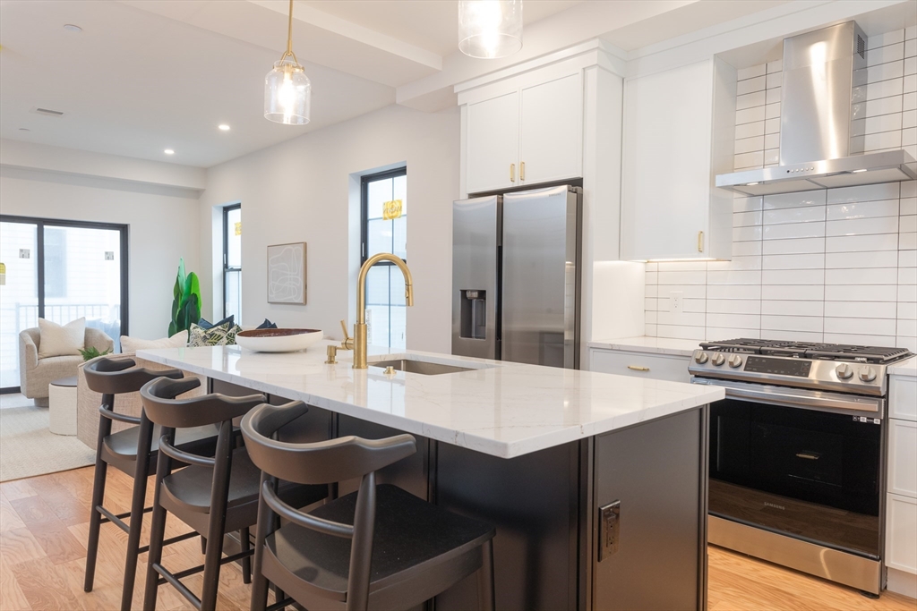 a kitchen with a stove a refrigerator and a dining table