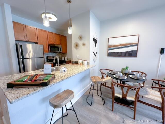 a kitchen with a dining table chairs and refrigerator