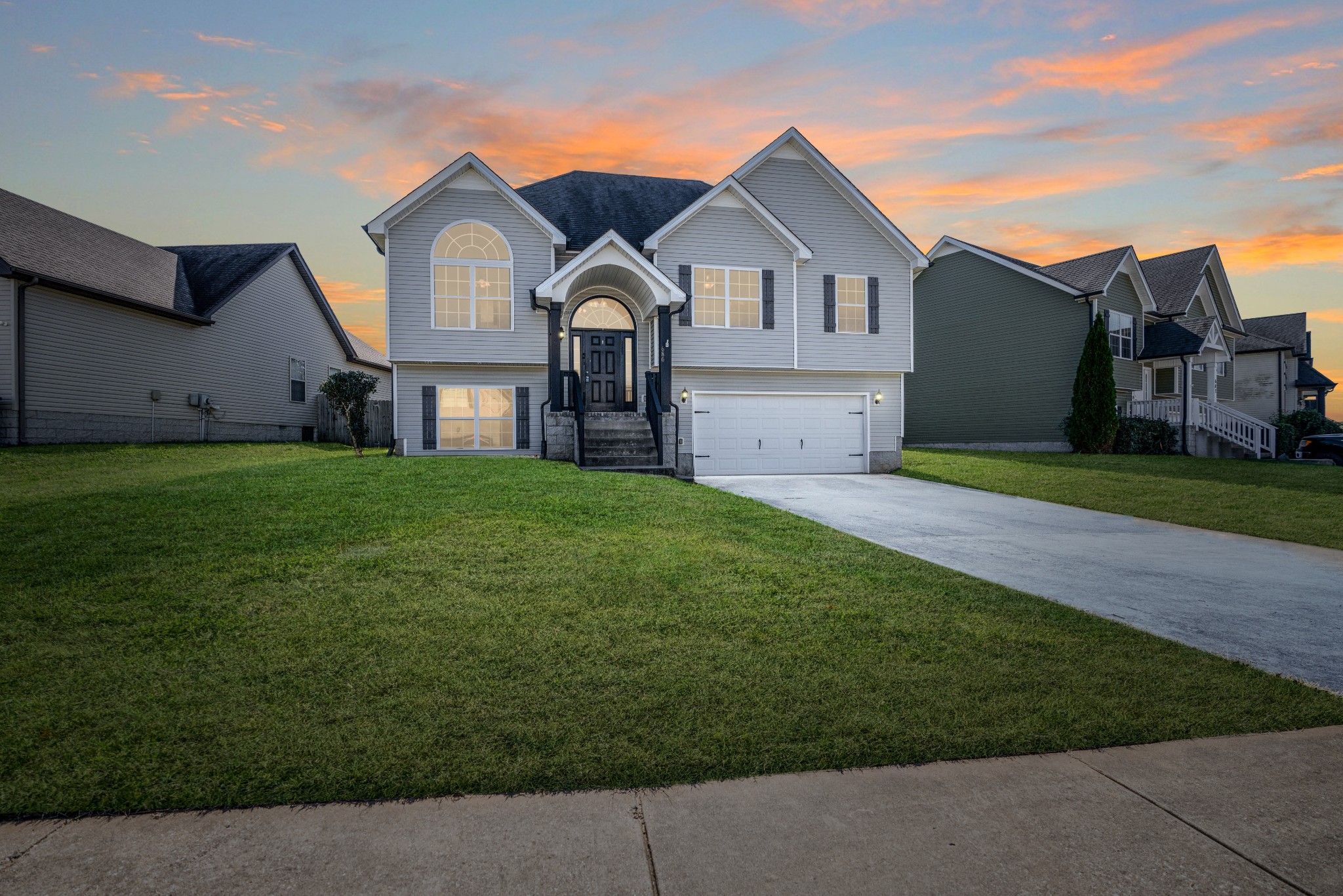 a front view of a house with a garden and yard