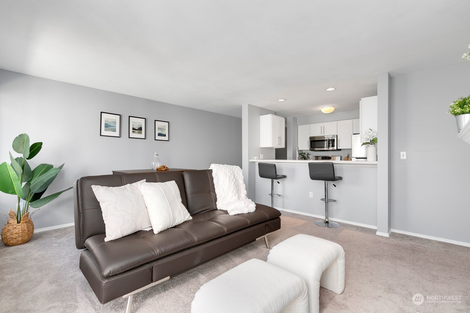 a living room with furniture and a dining table with kitchen view