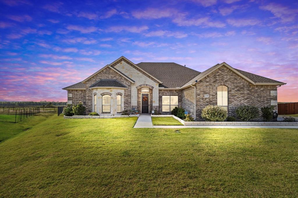 a front view of a house with yard and green space