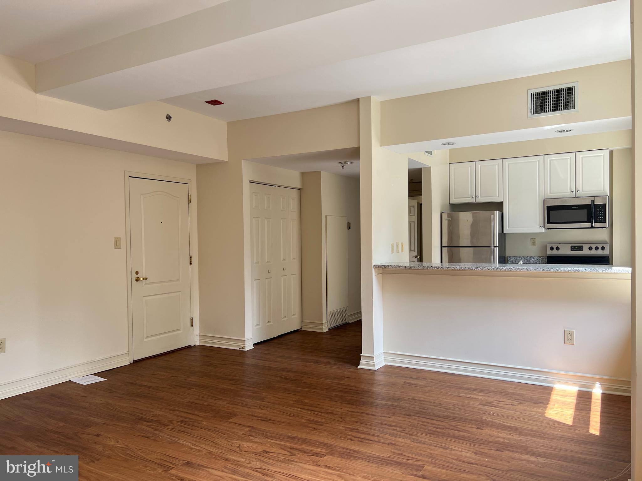 a view of a kitchen with wooden floor and a refrigerator