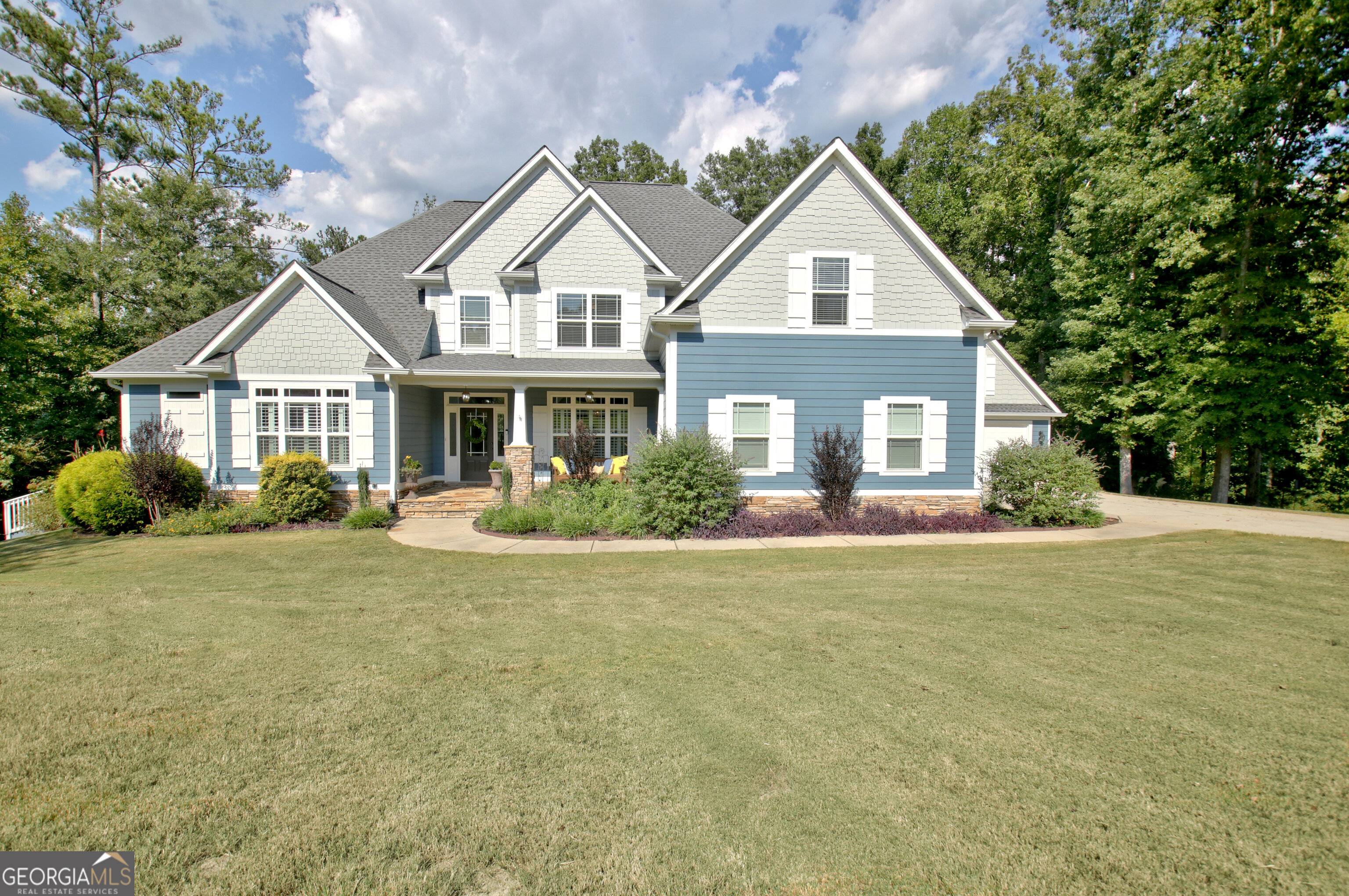 a front view of a house with a garden