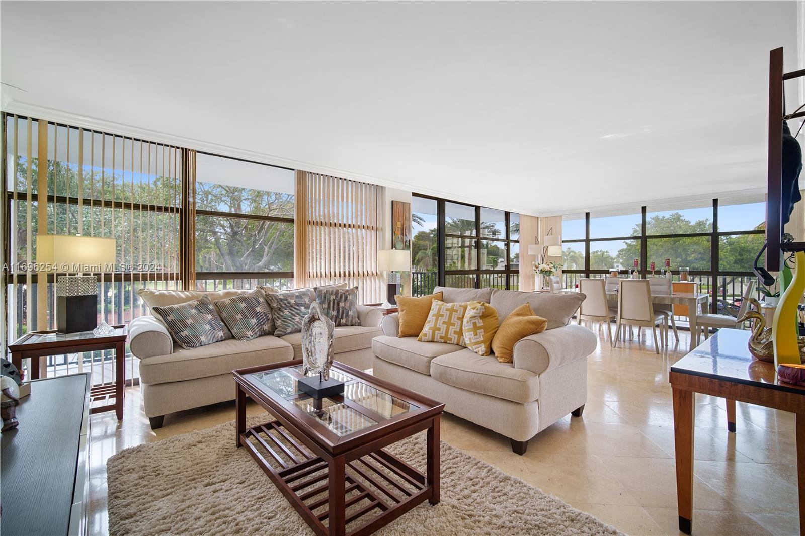 a living room with furniture a large window and a rug