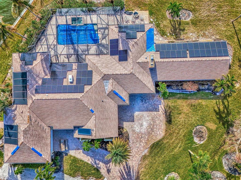 an aerial view of a house with swimming pool and large trees