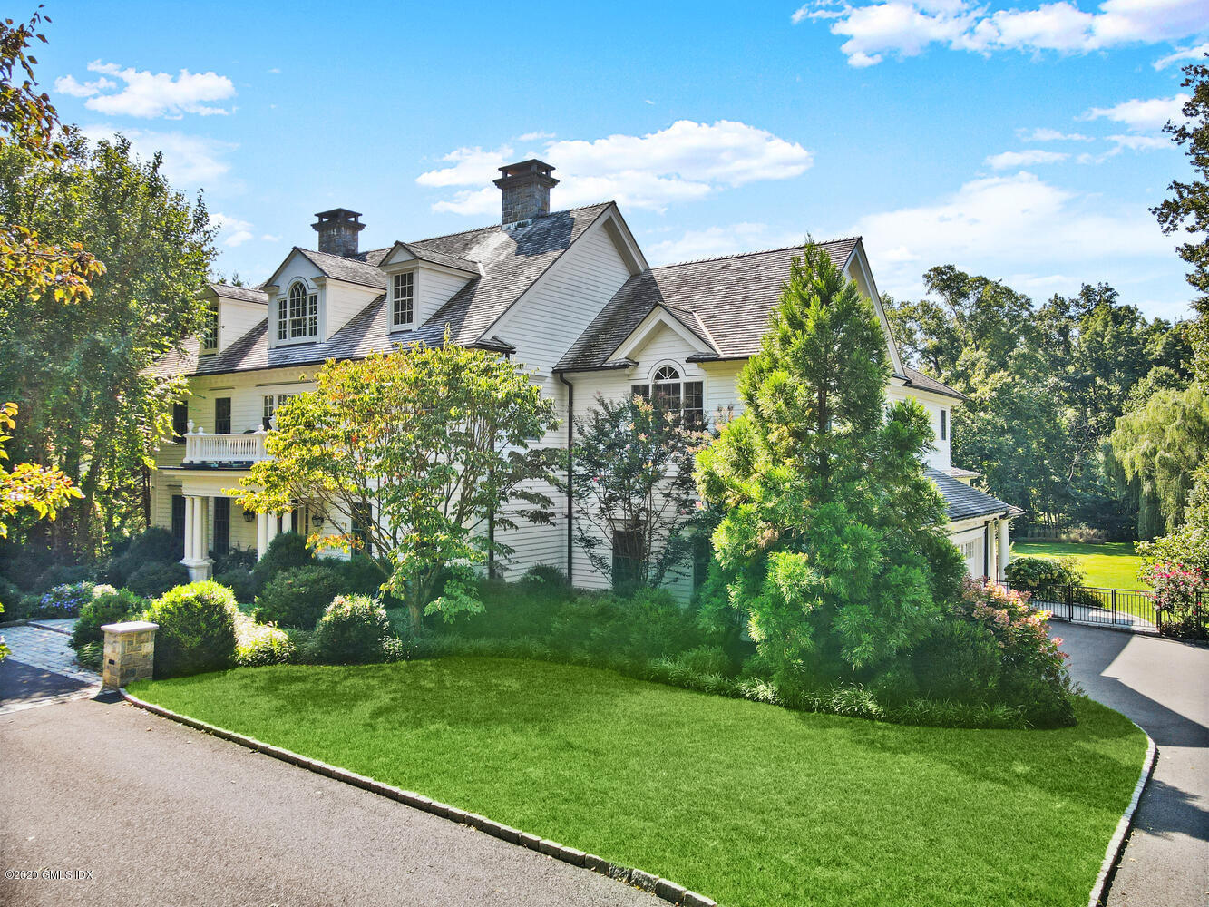 a front view of a house with a yard and potted plants