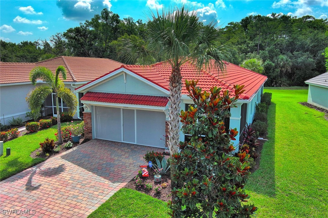 a view of a house with a yard and potted plants