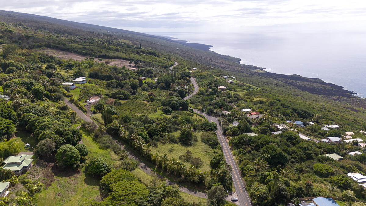 Gated property with paved roads and beautiful homes around. Subject is the property with Arika palms along the road going mauka (up the hill).  This photo is looking north.