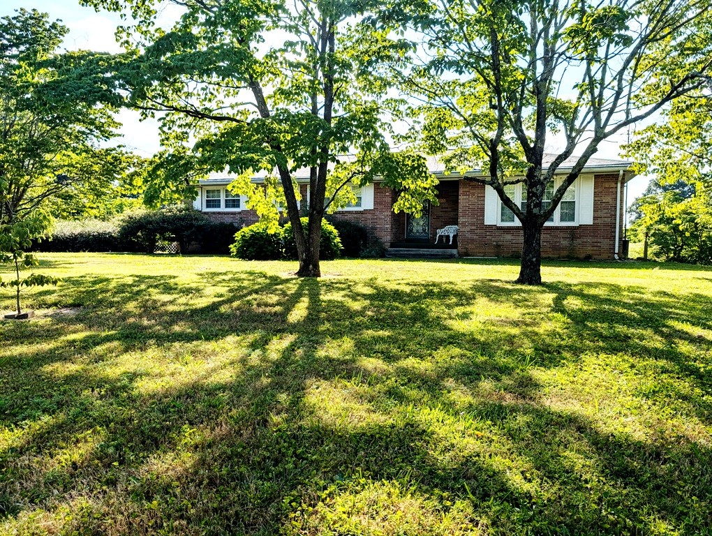 a house is sitting in middle of a yard