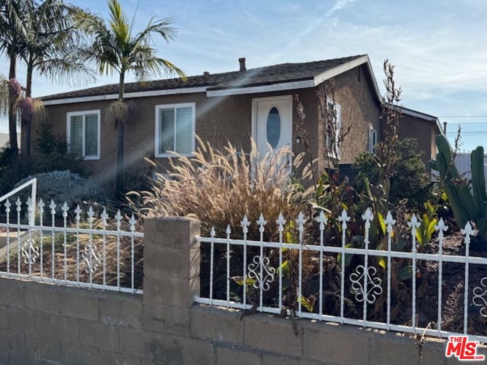 a view of a house with a large window and potted plants