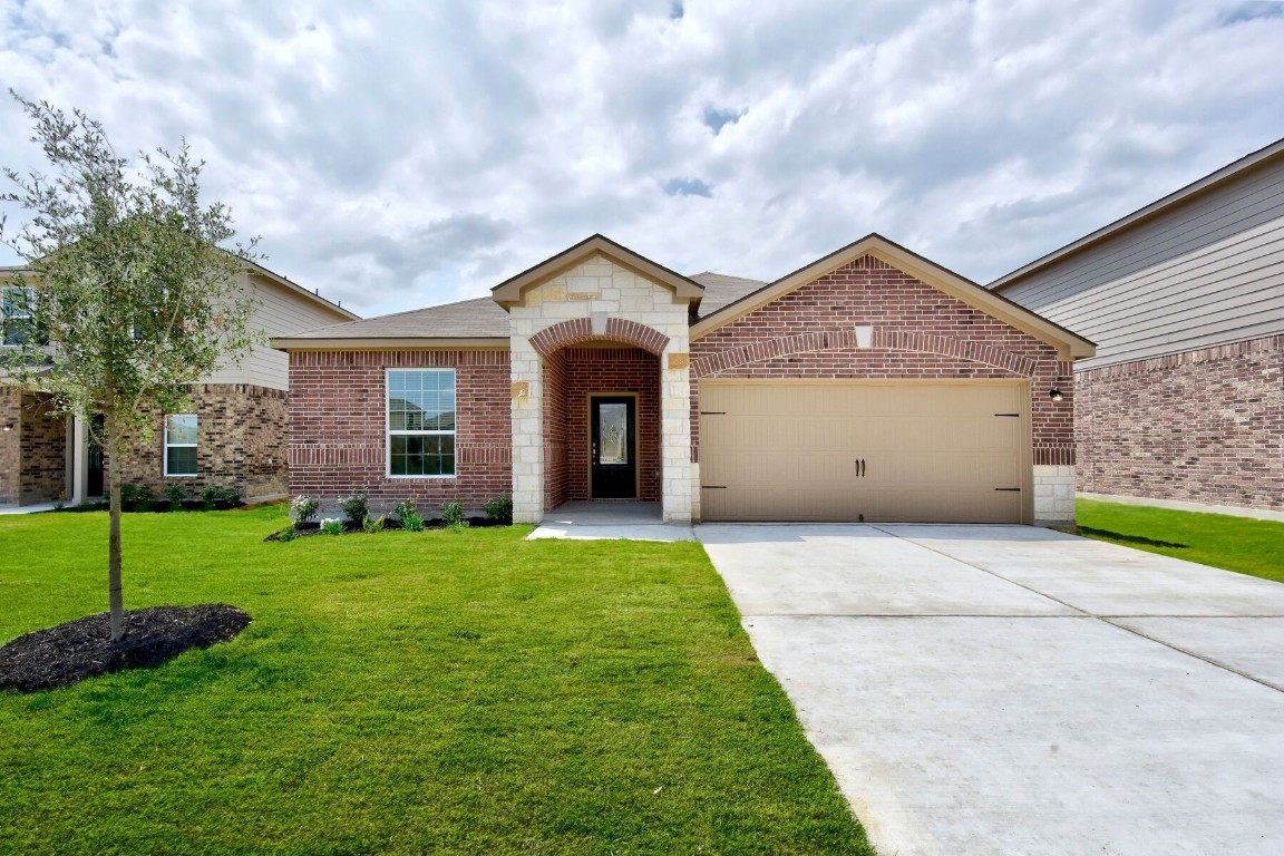 a front view of a house with a yard and garage