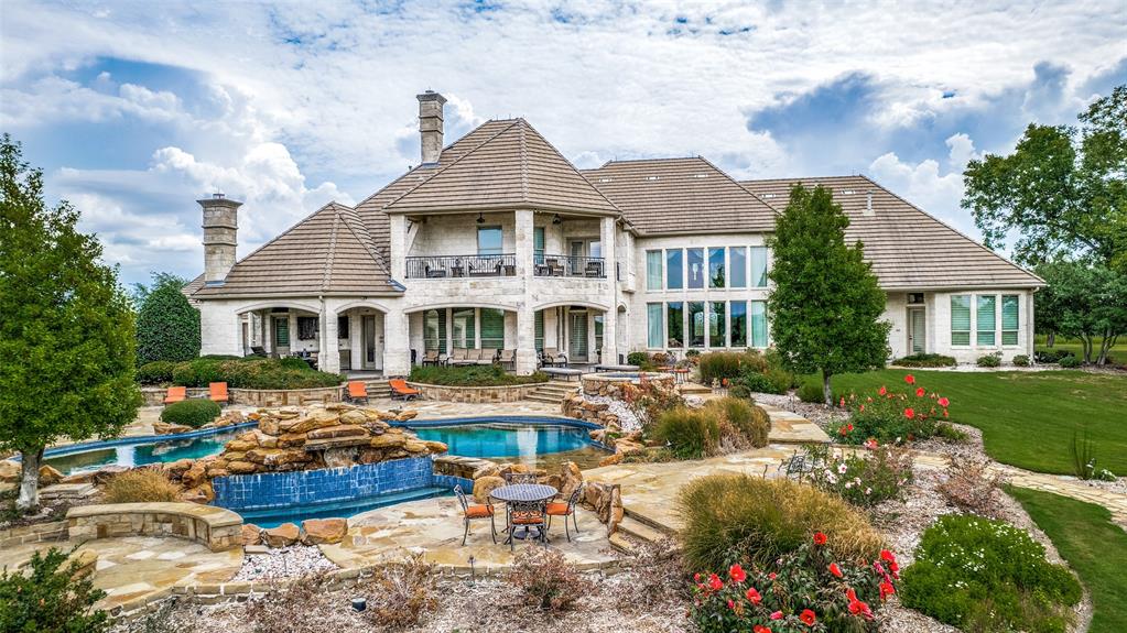 a front view of a house with garden swimming pool and outdoor seating