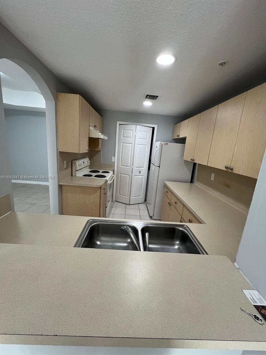 a kitchen with stainless steel appliances granite countertop a sink a stove and a refrigerator