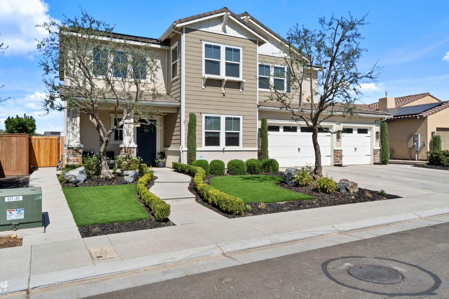 a front view of a house with a yard and potted plants