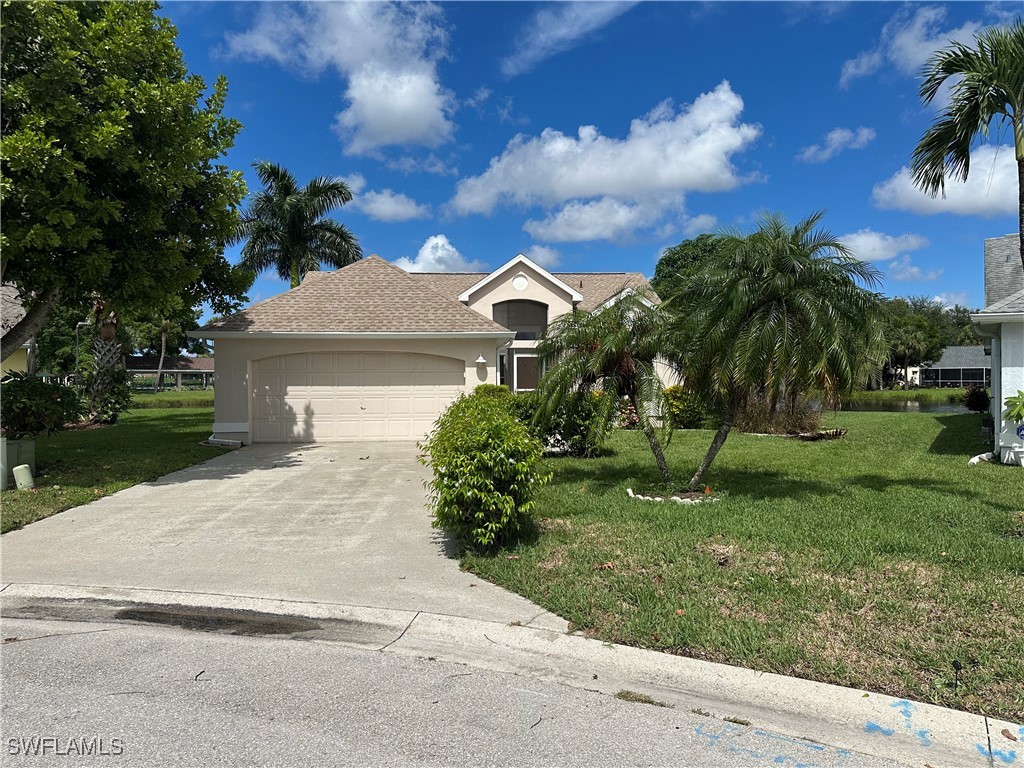 a front view of a house with a yard and a garage