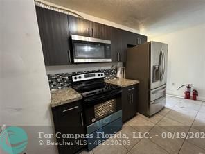 a kitchen with stainless steel appliances granite countertop a stove and a microwave