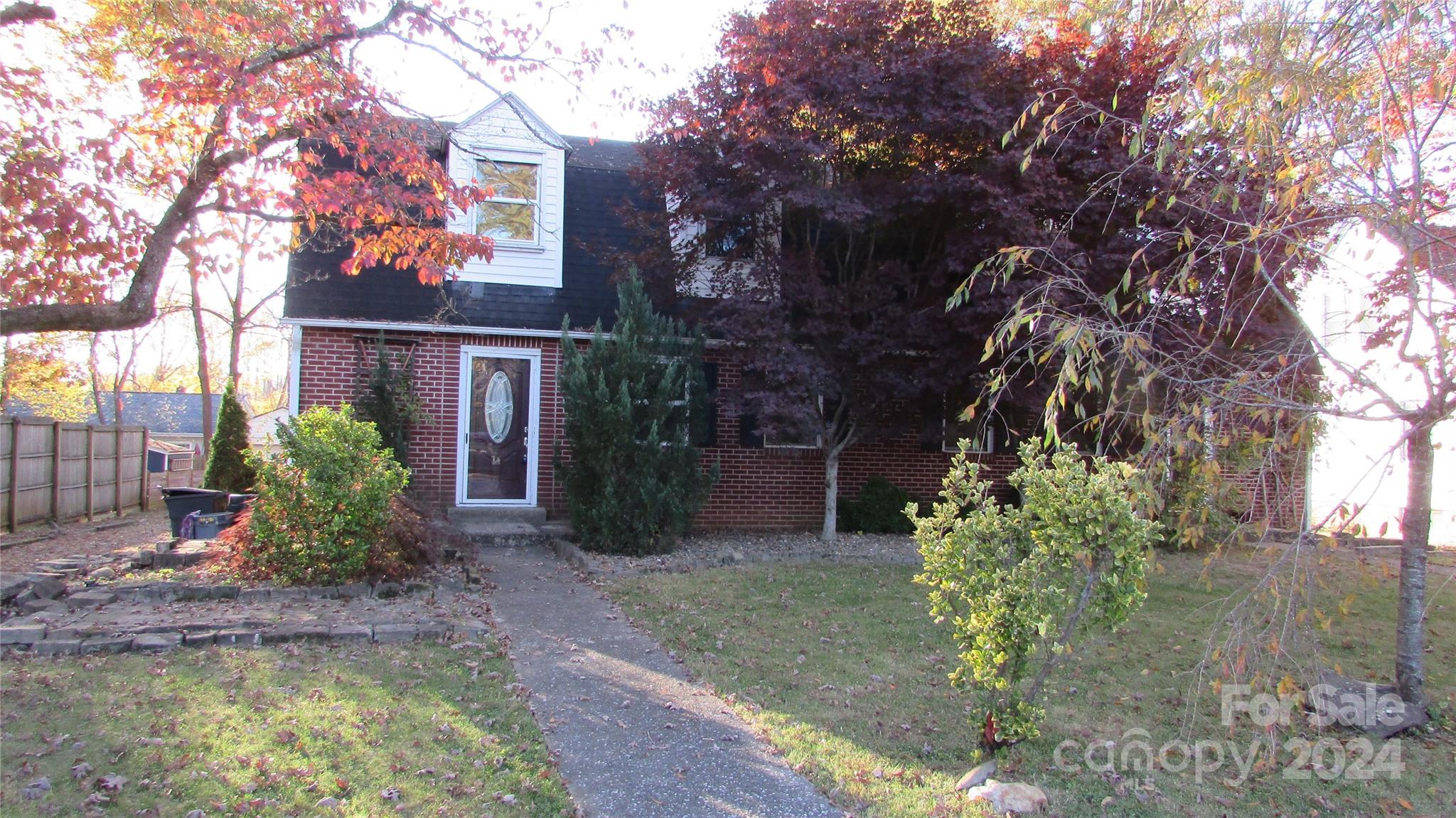 a view of a house with a yard tree and sitting area