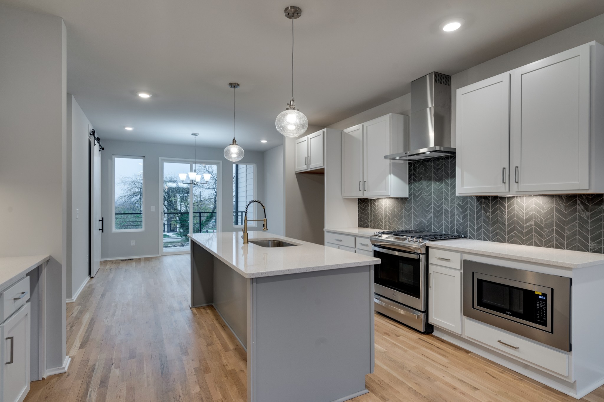 a kitchen with kitchen island a stove a sink a counter top space and cabinets