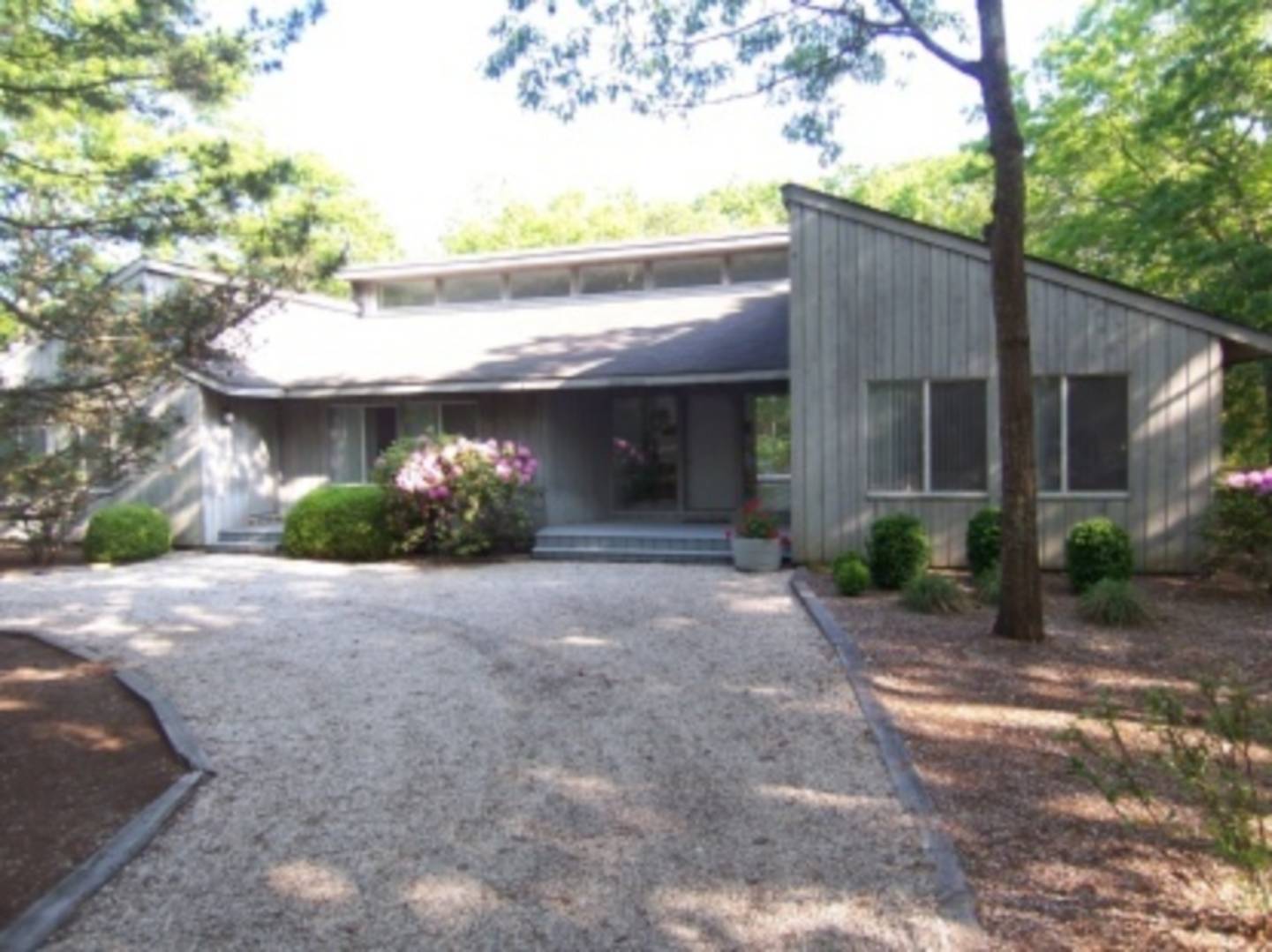 a view of a house with a yard and potted plants