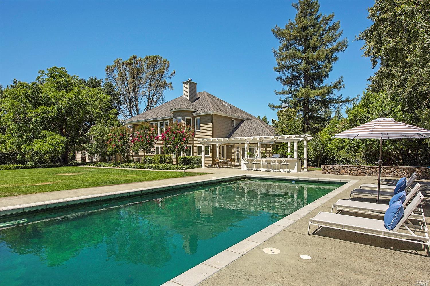 a view of a house with a yard and swimming pool