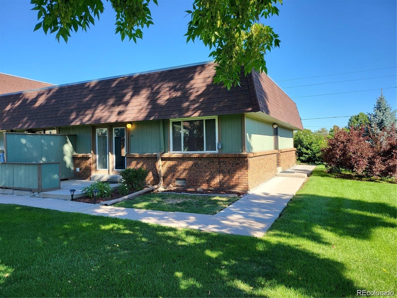 a view of a house with a yard potted plants and large tree