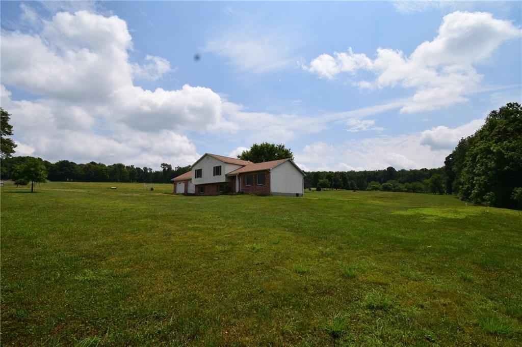 a view of a house with a big yard and a large tree