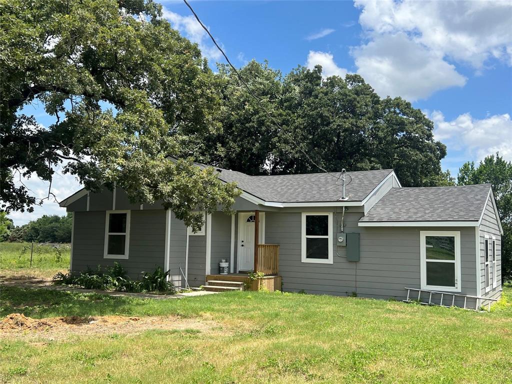 a front view of a house with yard and green space