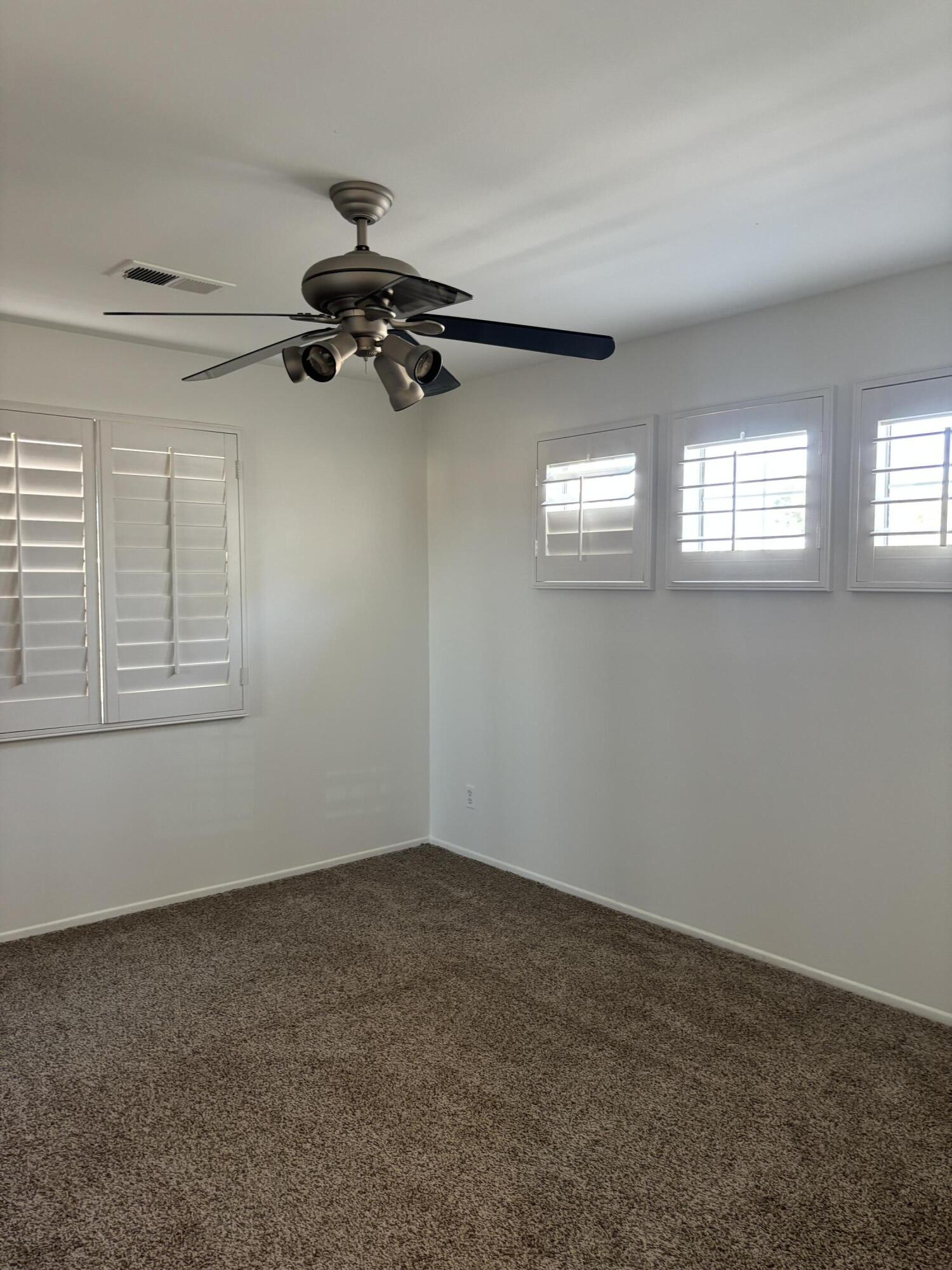 a view of a room with windows and a ceiling fan