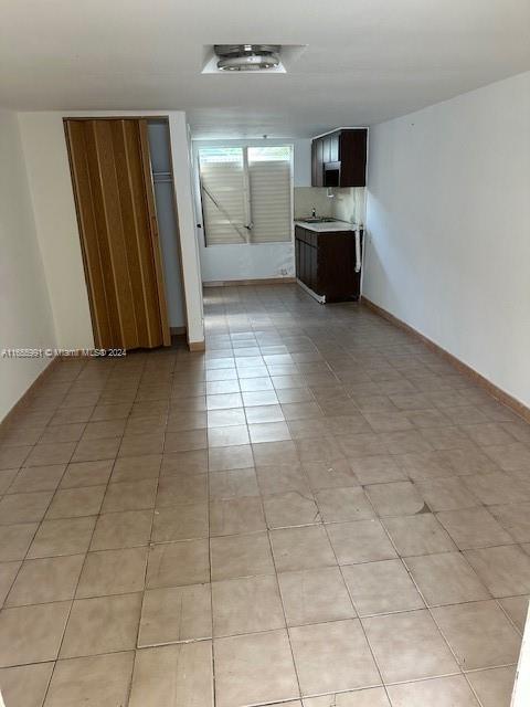 a view of a refrigerator in kitchen and an empty room