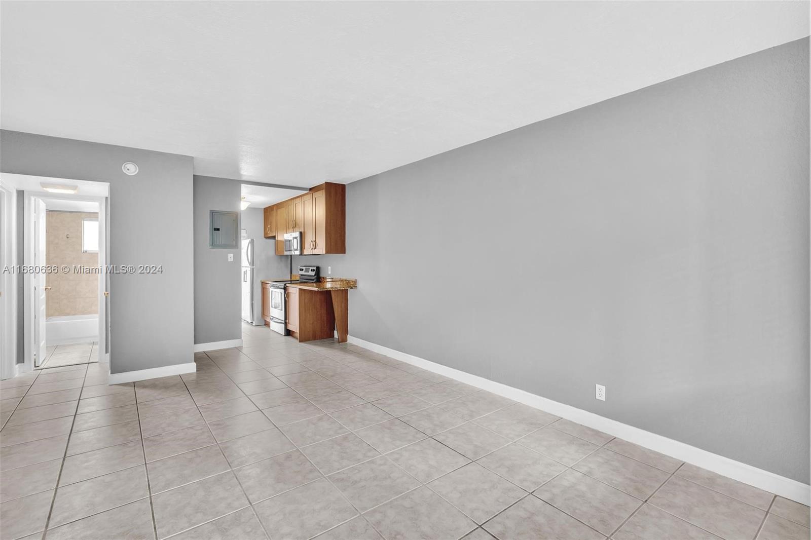 a view of a kitchen with refrigerator and more cabinets