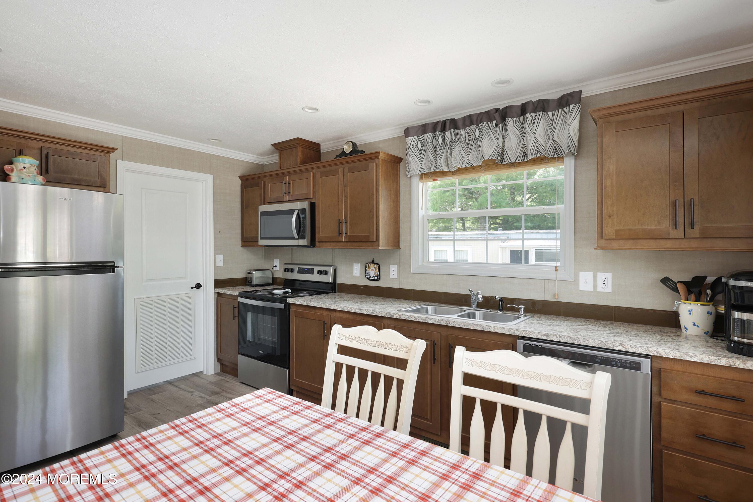 a kitchen with stainless steel appliances granite countertop a sink stove microwave and refrigerator