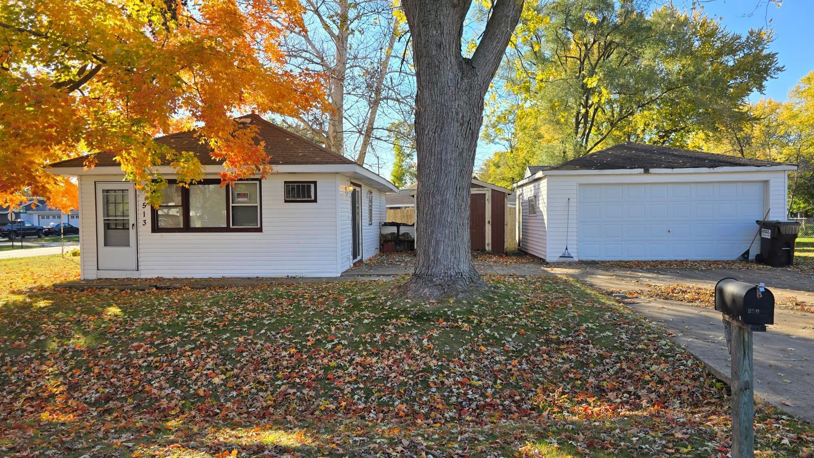 a view of a house with a yard and large tree