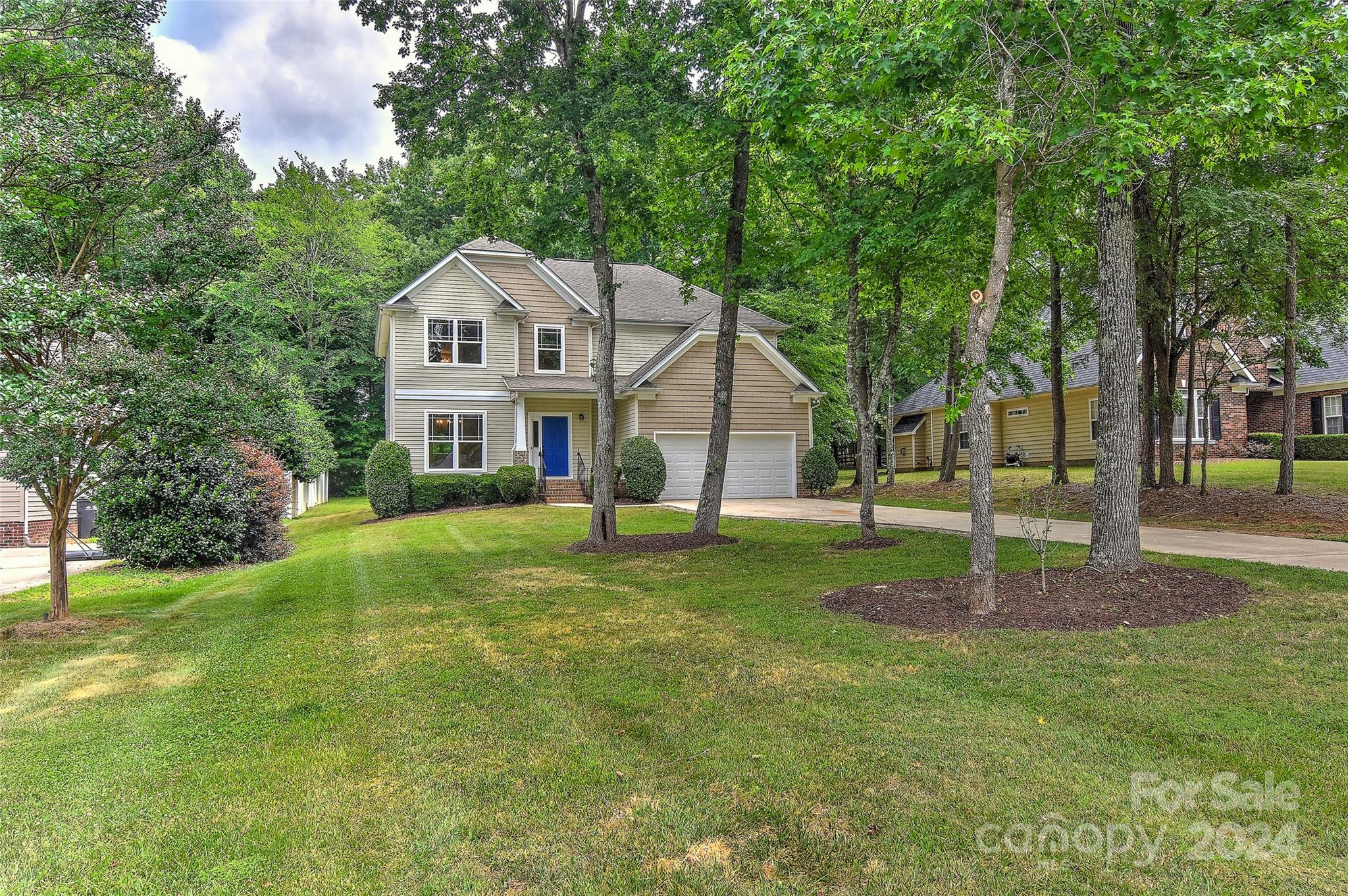 a front view of a house with a yard and trees